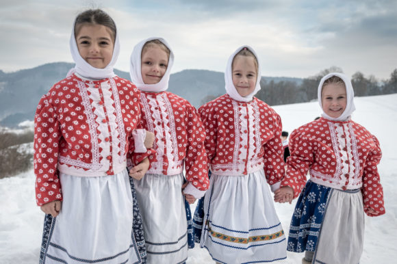 Fašiangové časy, jedni pijú, druhí jedia za stolom klobásy…