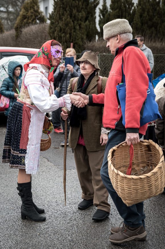 Fašiangové časy, jedni pijú, druhí jedia za stolom klobásy…